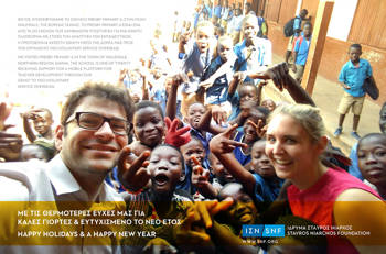 Two members of the Stavros Niarchos Foundation take a picture with many smiling kids in Ghana